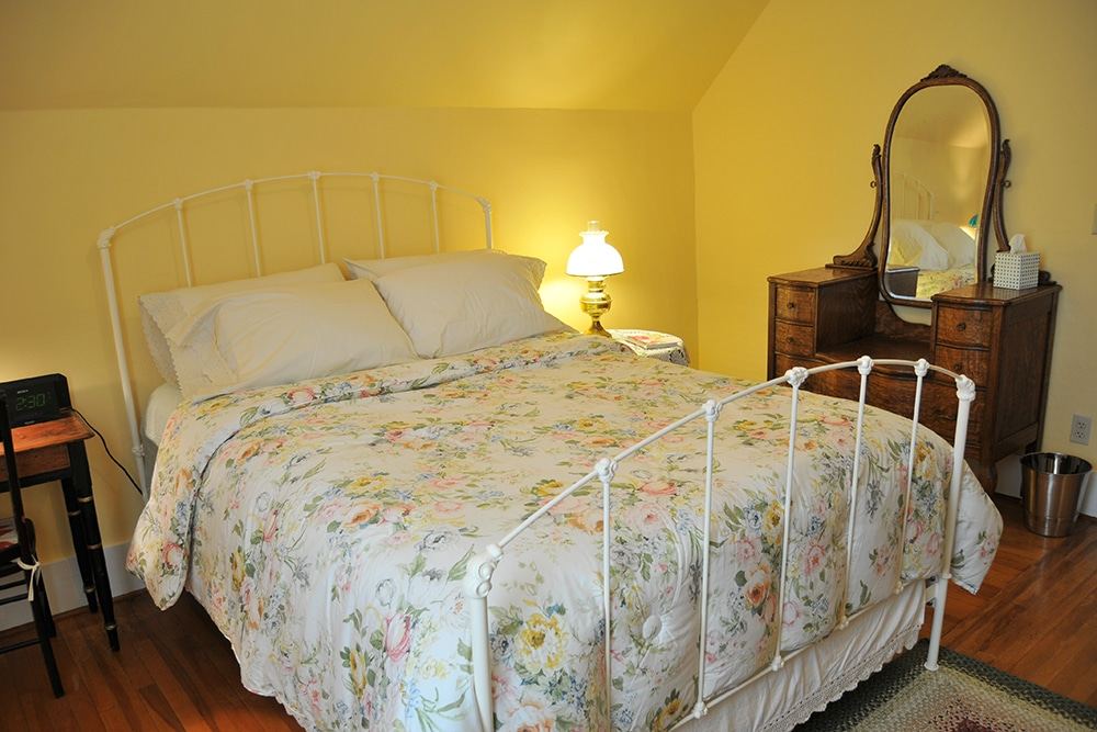 Mary Mackie Room with queen bed, yellow walls and antique furnishings